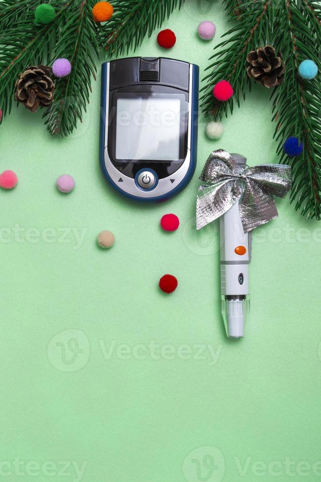 banner de Natal com decorações do feriado e um glicosímetro para medir o açúcar no sangue em um fundo colorido. conceito de cartão de Natal para médicos com espaço de cópia. foto vertical. fechar-se.