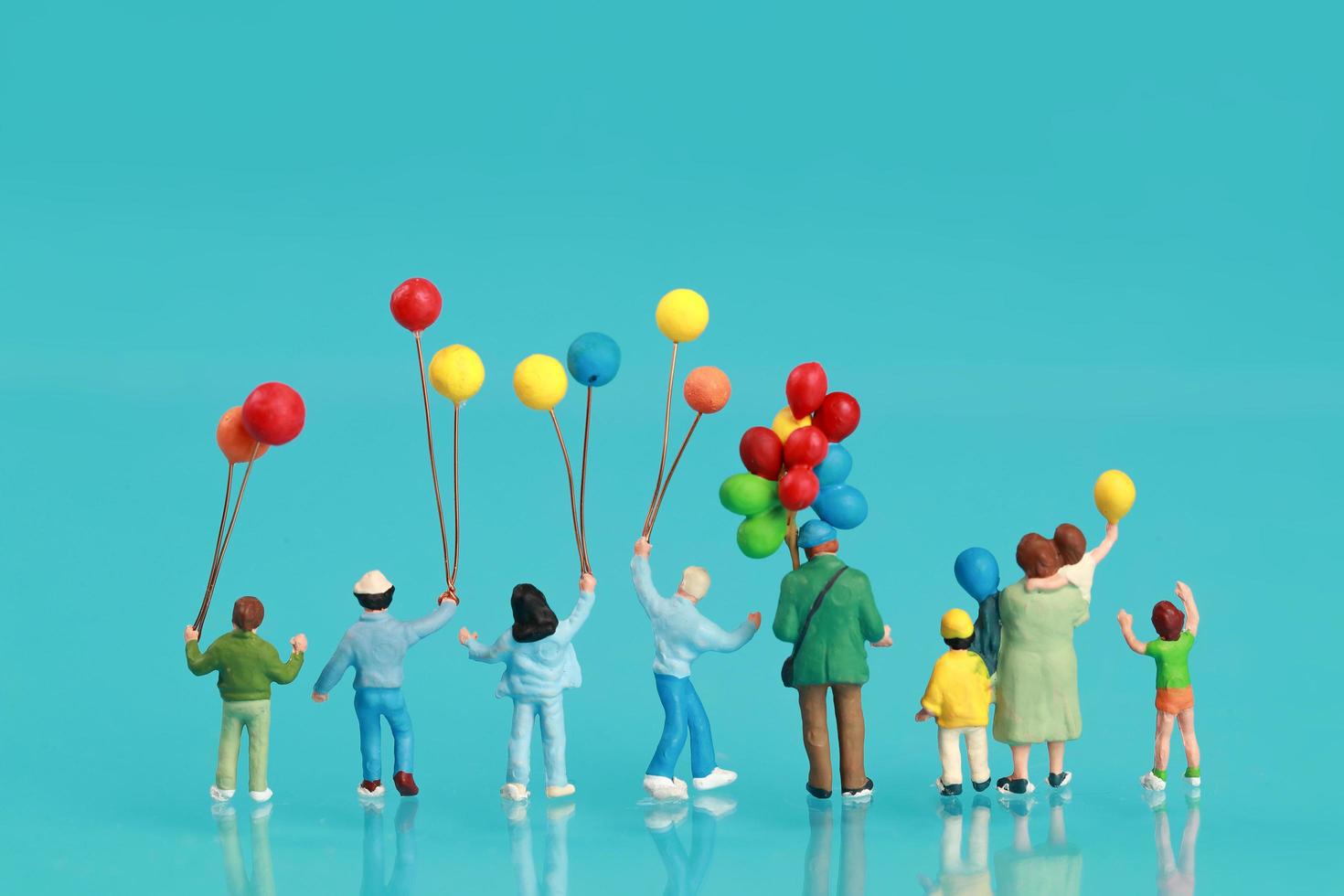 vista traseira de um grupo de família feliz se divertindo e segurando um balão como pano de fundo foto