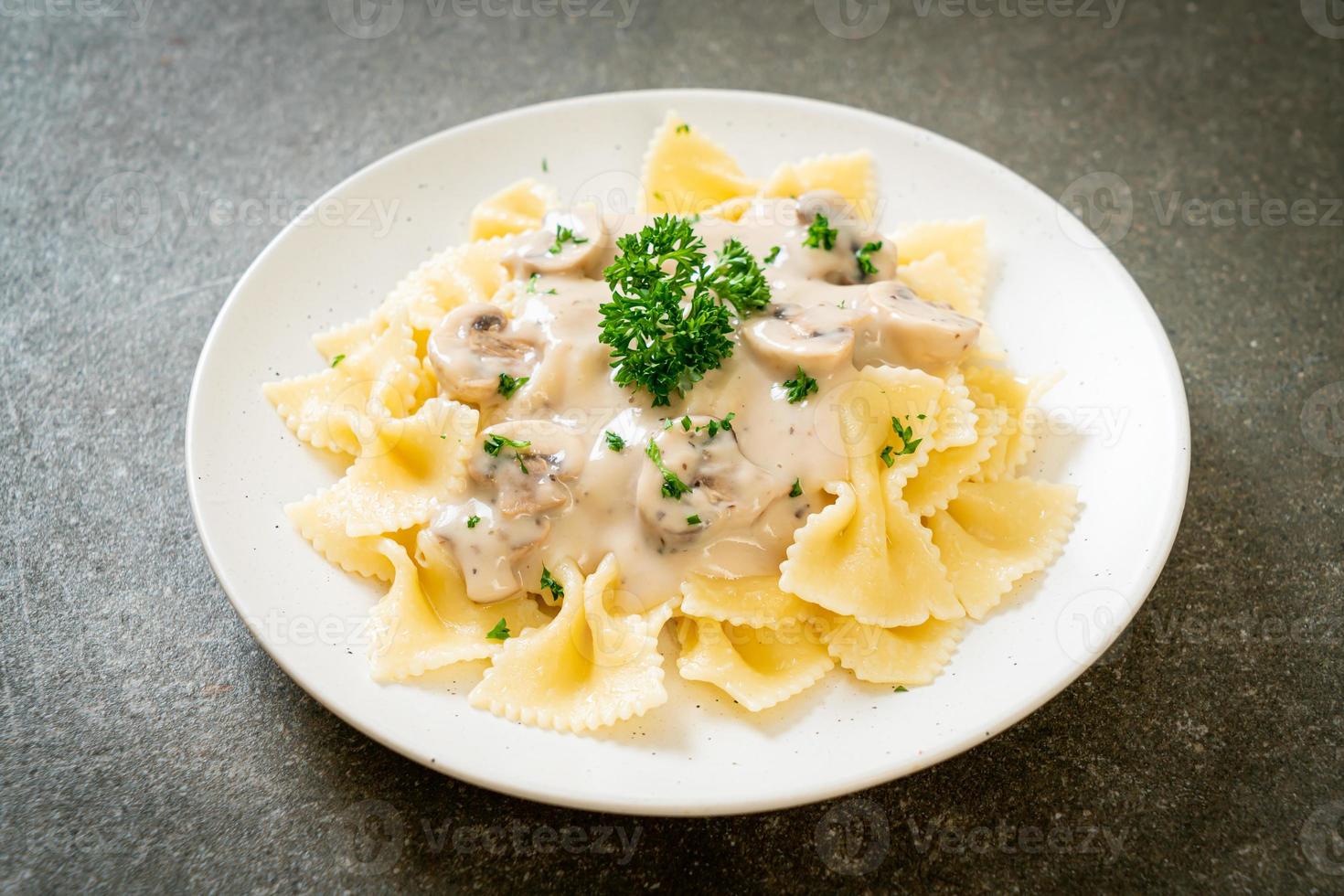 macarrão farfalle com molho de creme de cogumelos branco foto