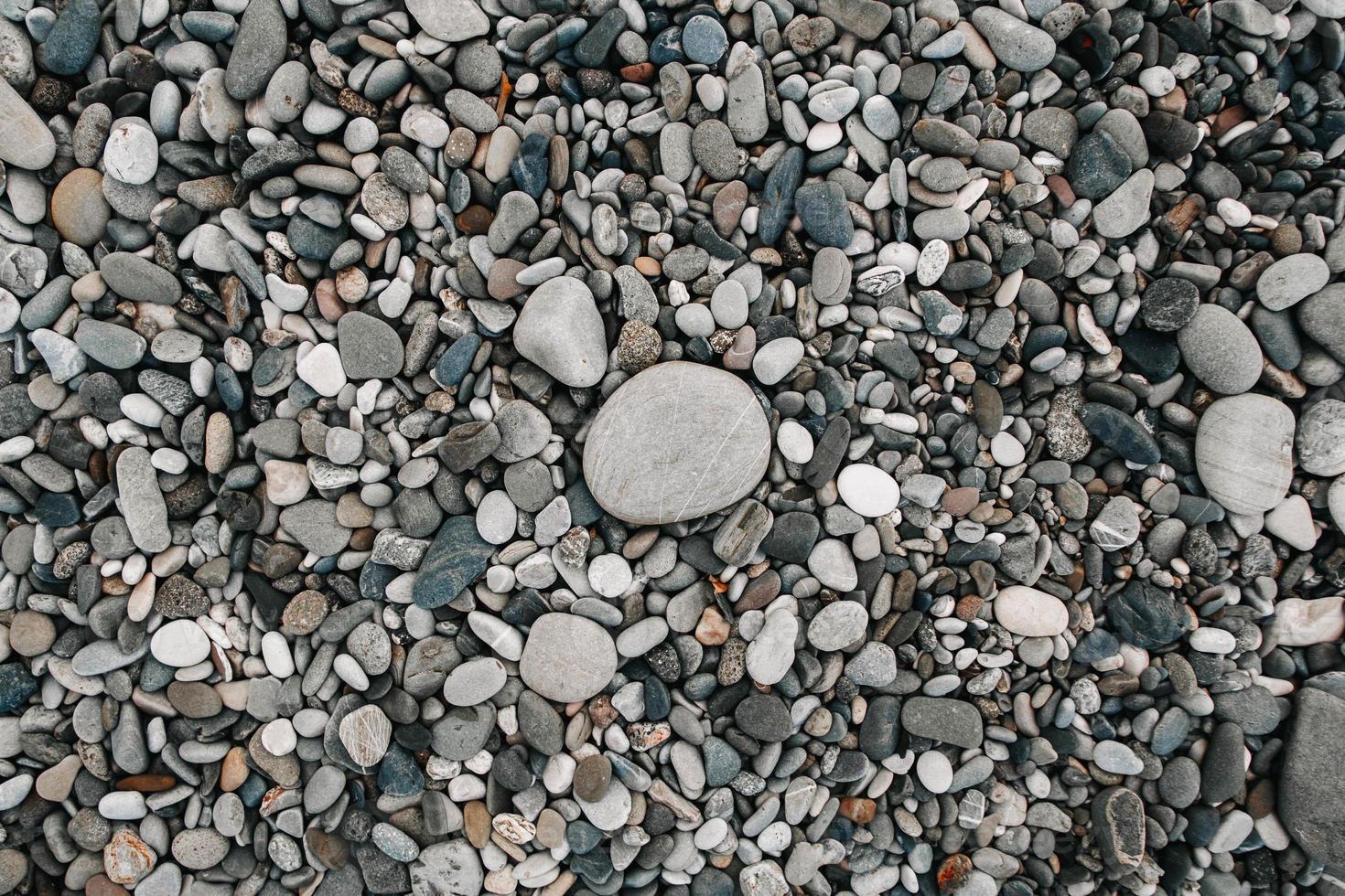 padrão de cascalho de pedras coloridas. fundo de seixos de natureza abstrata. fundo de pedra. praia de seixos do mar. vista do topo. foto