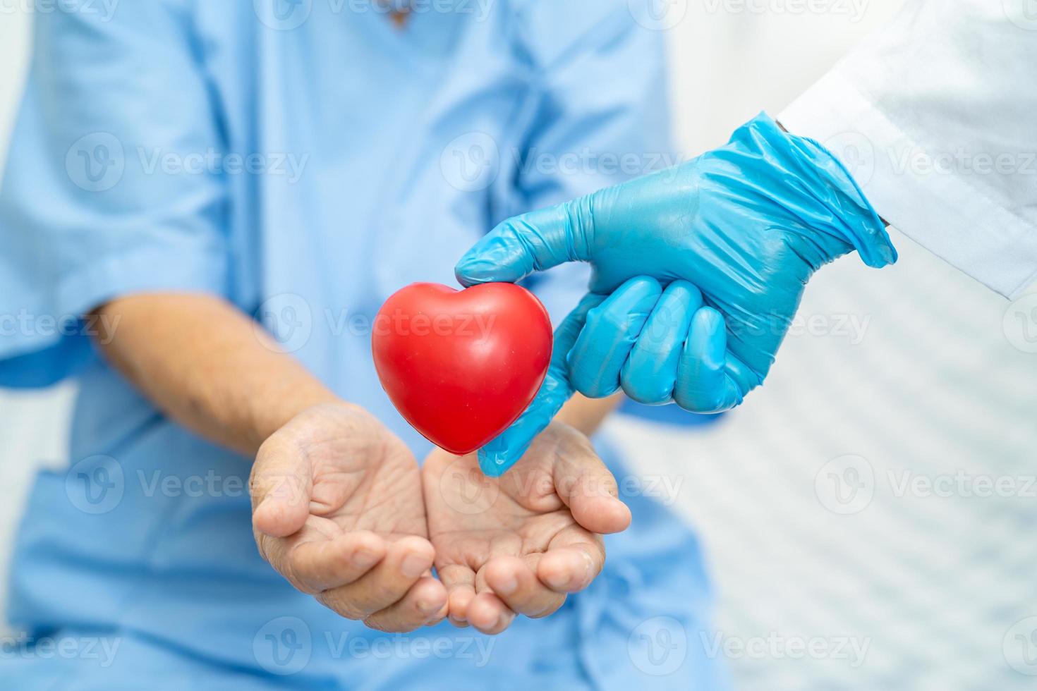 médico dá coração vermelho a paciente idosa ou idosa asiática, conceito médico forte e saudável foto