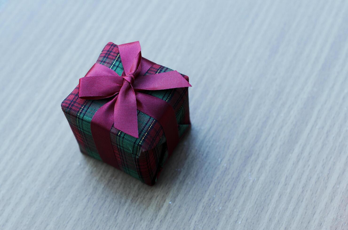 Feche acima da caixa de presente de Natal com fundos antigos de mesa de madeira foto