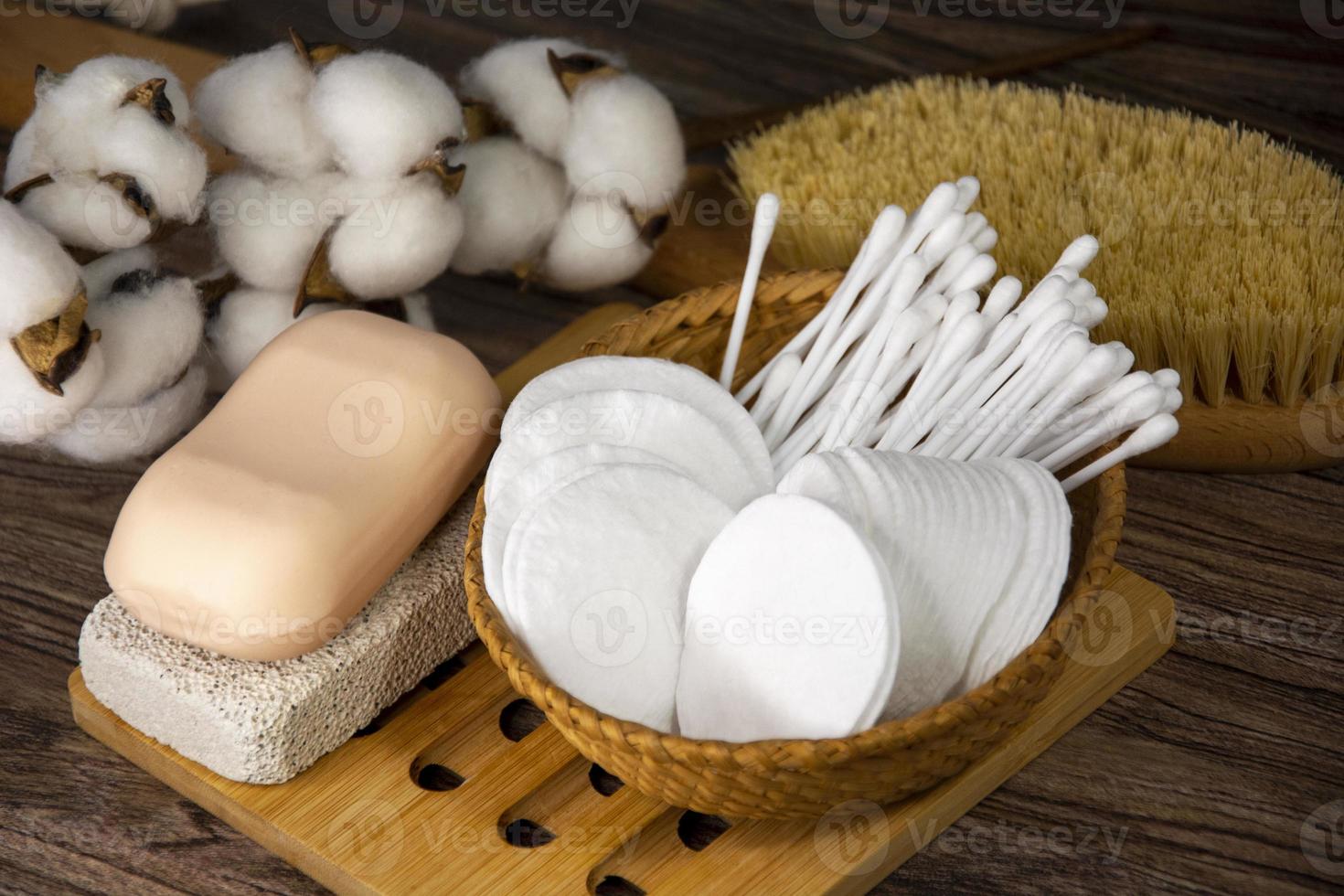 cotonetes, discos de algodão natural, pedra-pomes e sabão. artigos de higiene na cesta. foto