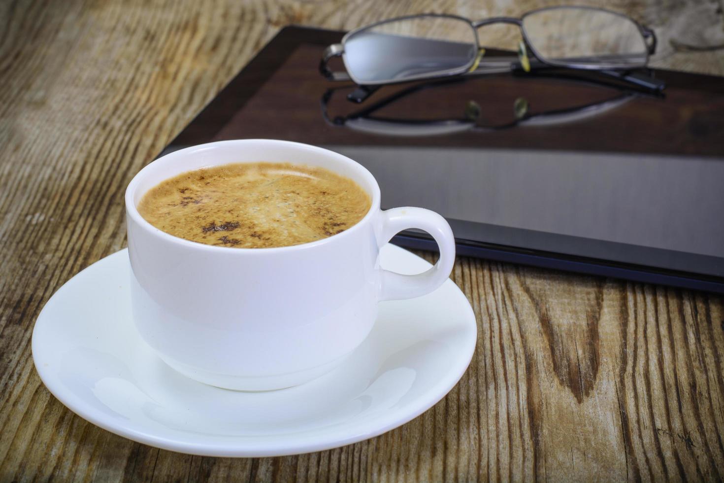 laptop empresário no local de trabalho, café e óculos de sol foto