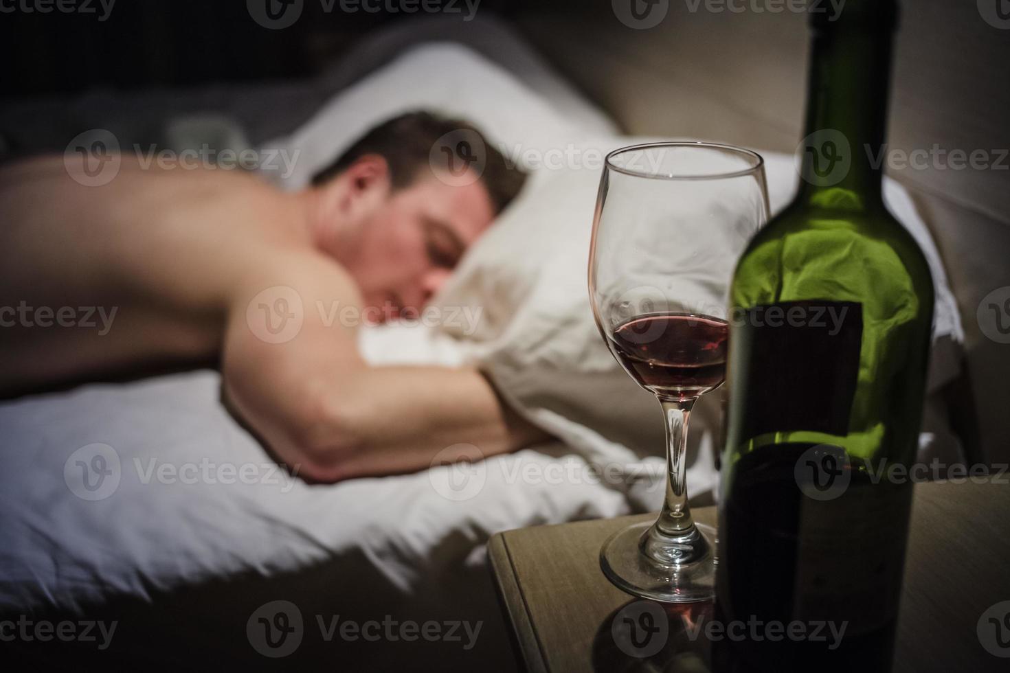 homem de ressaca em uma cama a noite foto