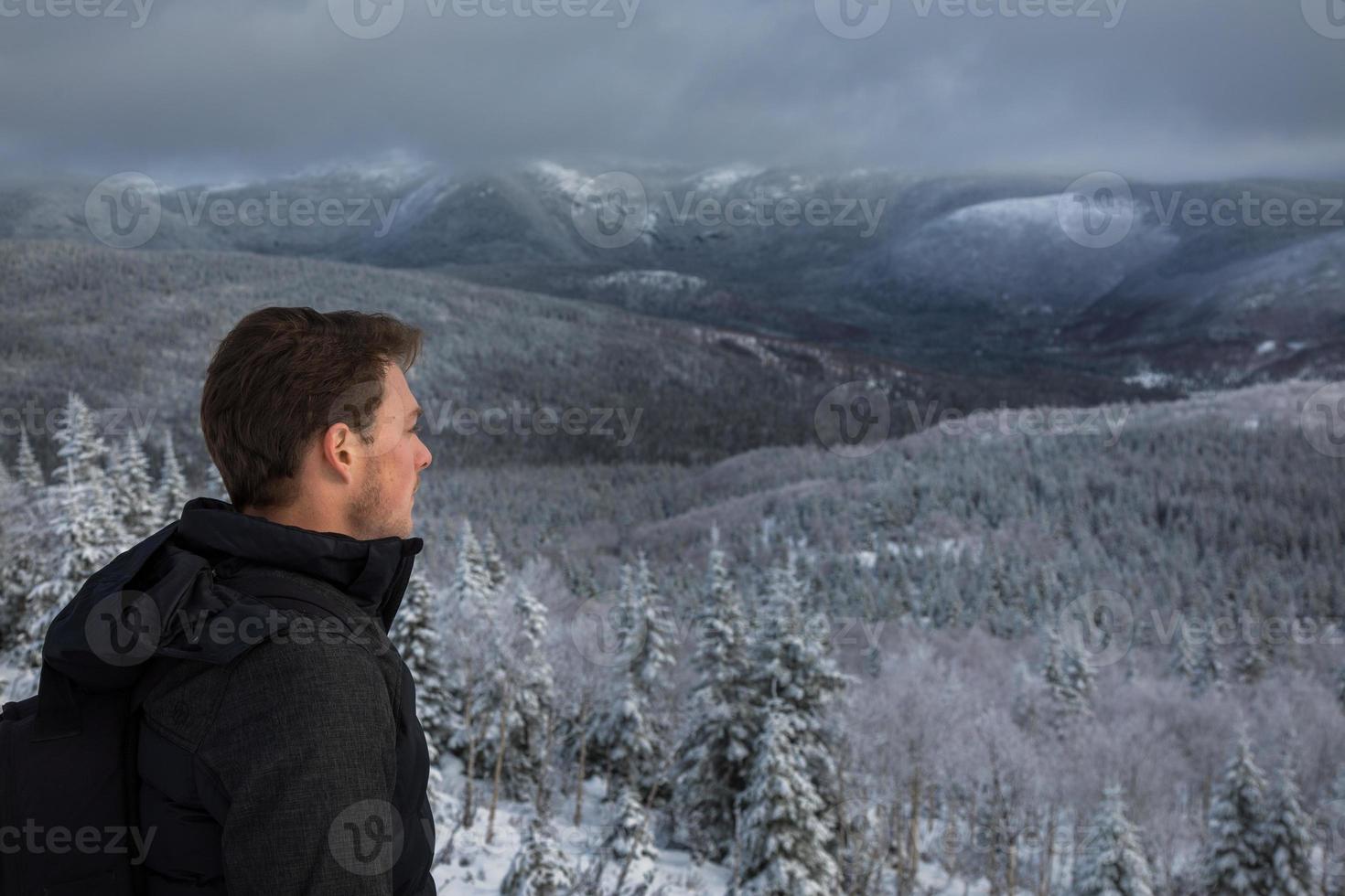 homem no topo da montanha no inverno foto