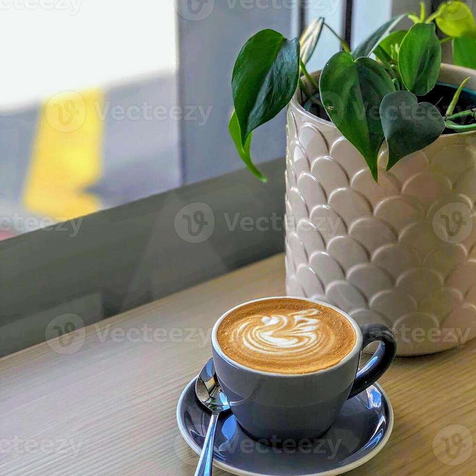 leite café com formato de árvore em um copo branco transparente sobre um fundo verde foto