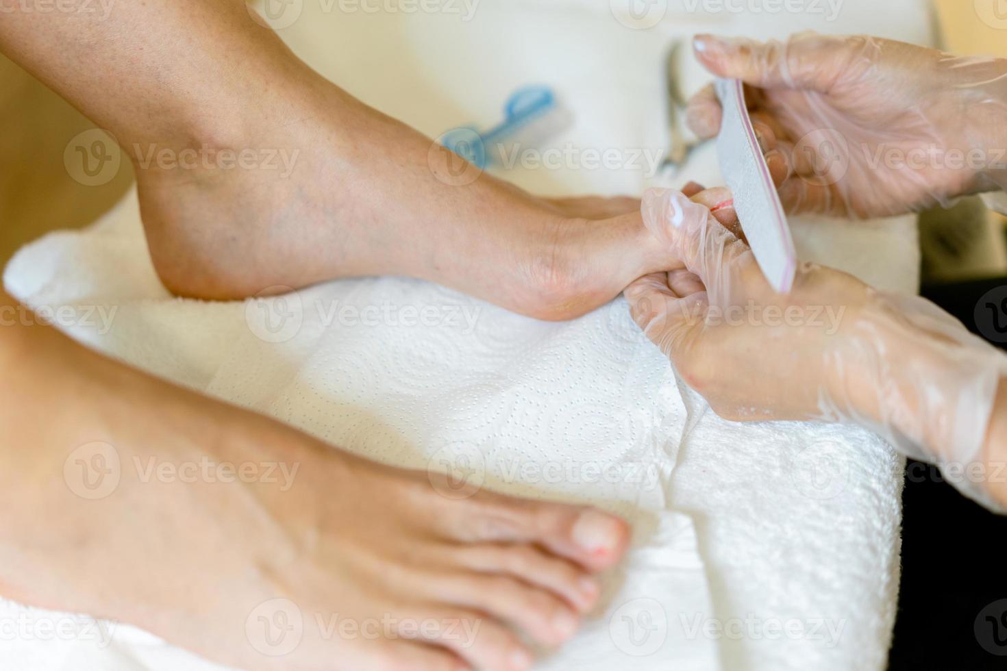 esteticista fazendo pedicure pintando as unhas de sua cliente em um centro de beleza. foto