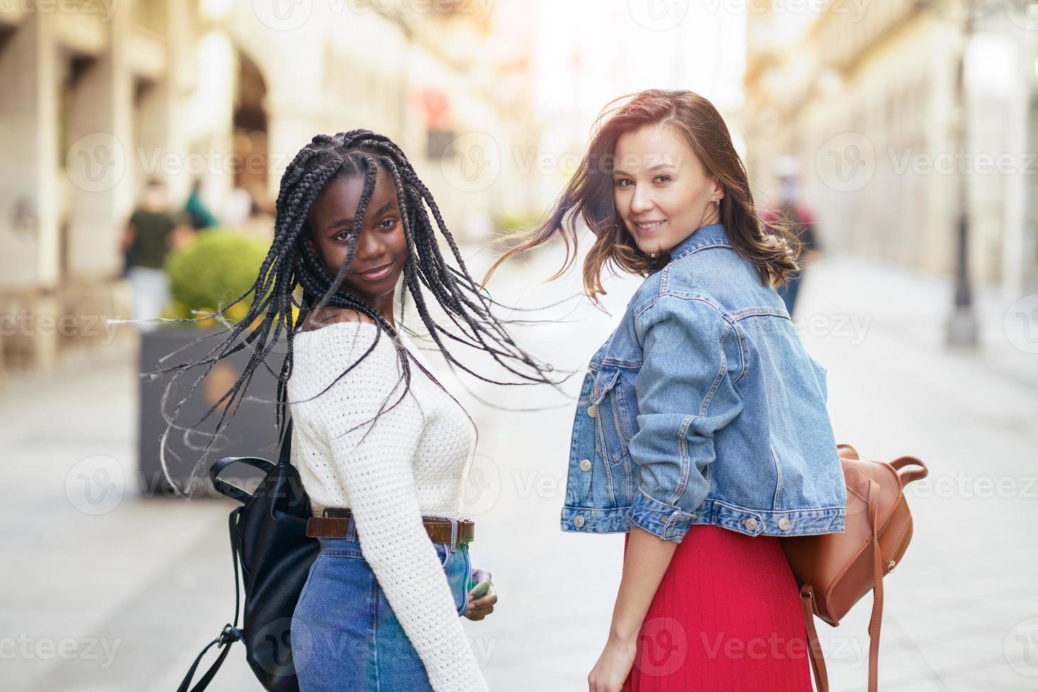 duas amigas se divertindo juntos na rua. amigos multiétnicos. foto