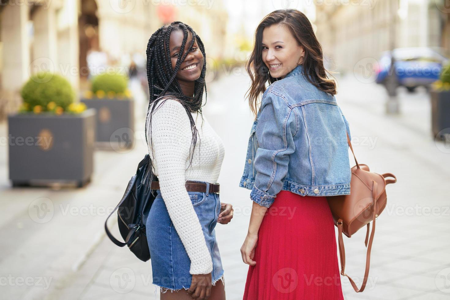 duas amigas se divertindo juntos na rua. amigos multiétnicos. foto