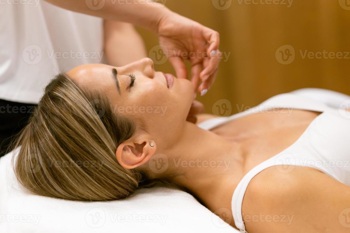 mulher de meia-idade, tendo uma massagem na cabeça em um salão de beleza. foto