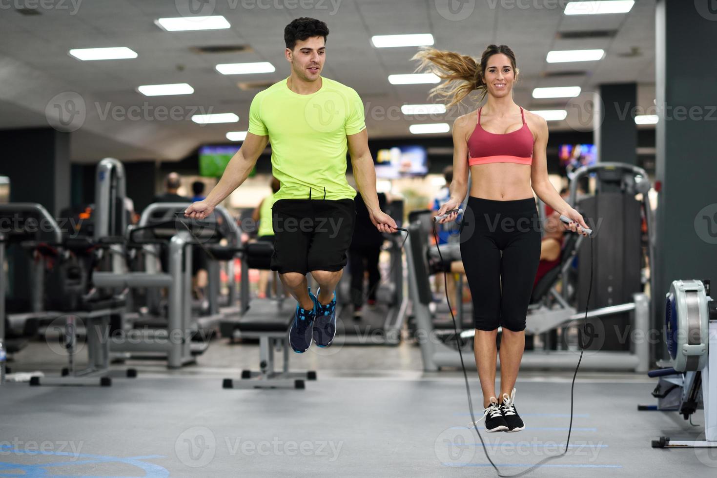 homem e mulher treinando com pular corda no ginásio crossfit foto