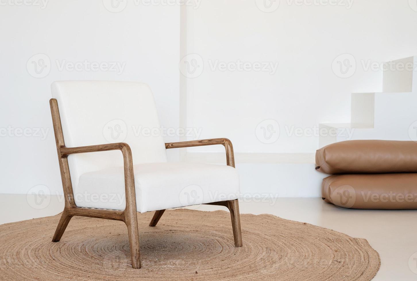 luz mínima e design interior arejado, cadeira branca e bege, tapete e travesseiros foto