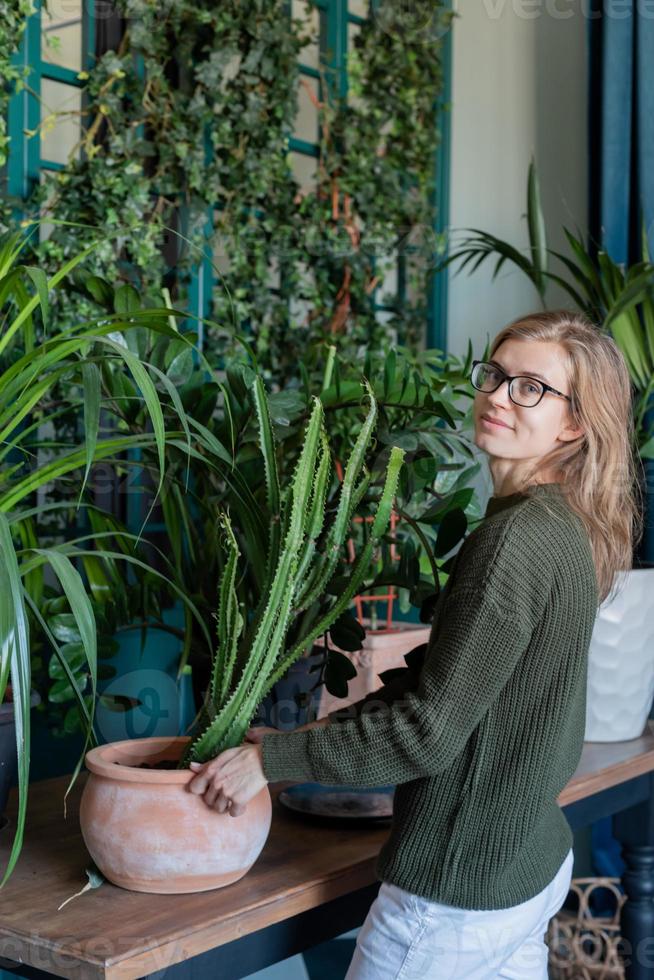 jovem cuidando das plantas em casa foto