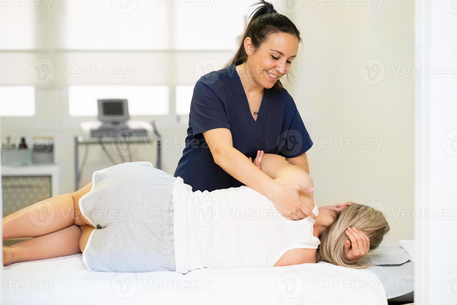 Fisioterapeuta inspecionando seu paciente em um centro de fisioterapia. foto