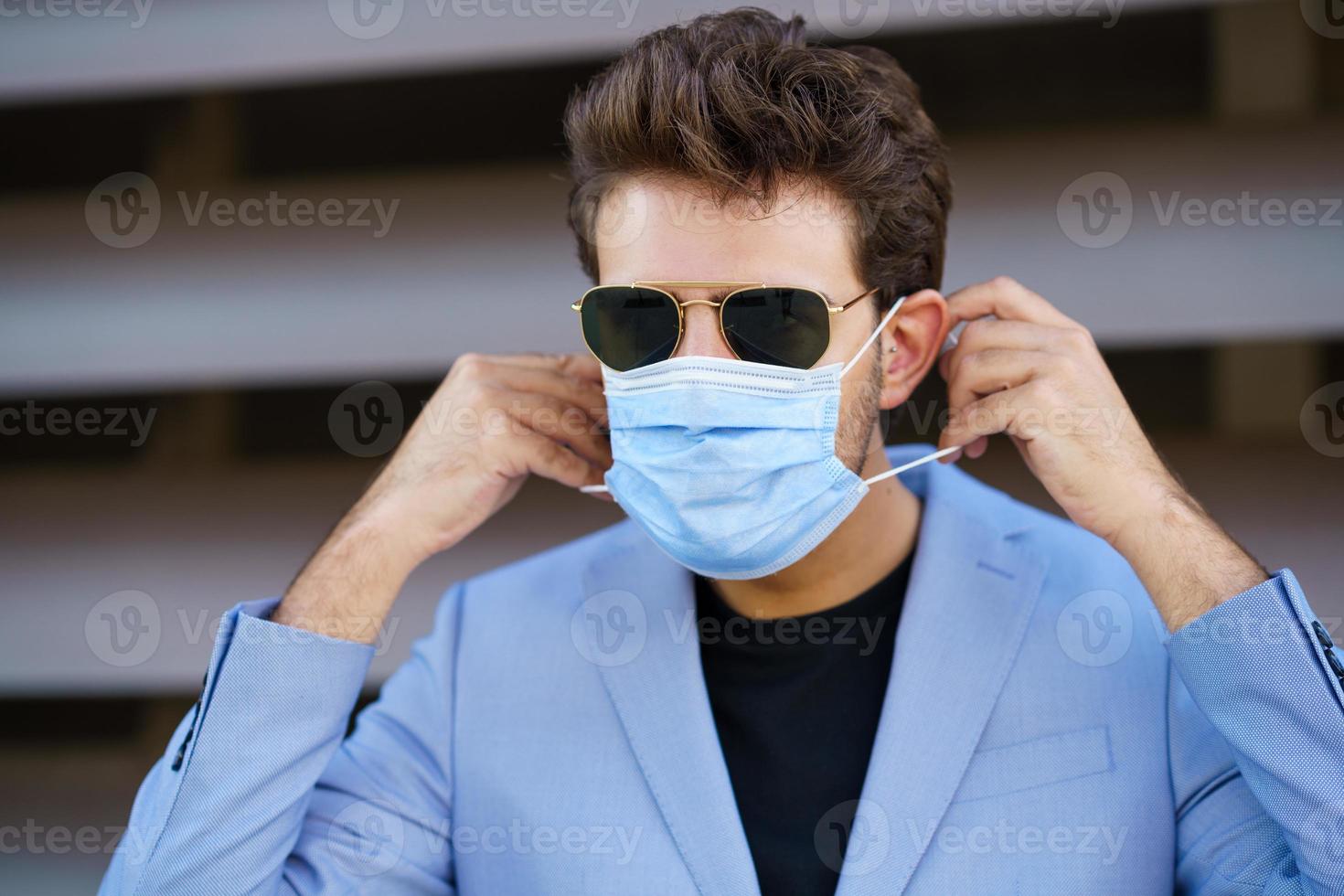empresário colocando uma máscara cirúrgica para se proteger contra o coronavírus. foto