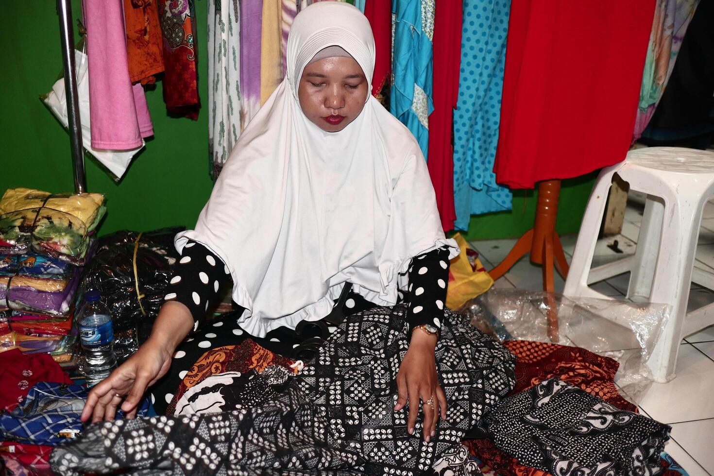 comerciantes de batique quando organizam seus itens de venda na loja em pekalongan java central indonesia foto