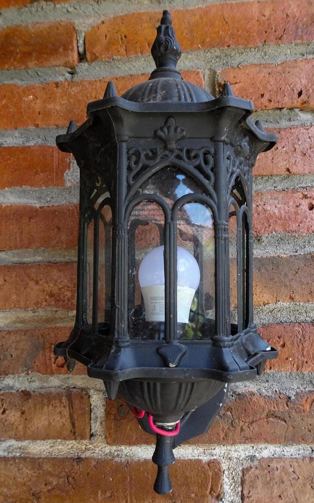 uma lâmpada antiga pendurada na frente do prédio. uma bela lanterna para decorar o exterior do edifício tradicional. foto