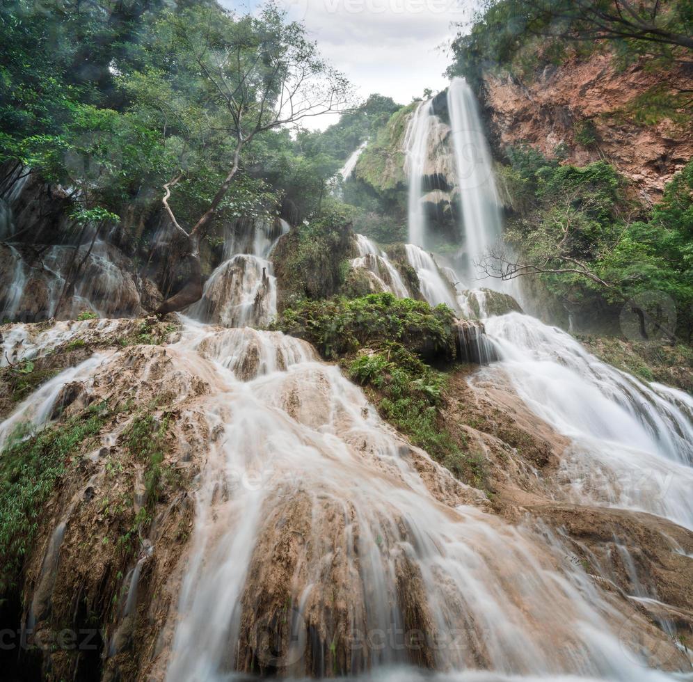 cachoeira erawan 7º andar com água fluindo na floresta tropical do parque nacional foto