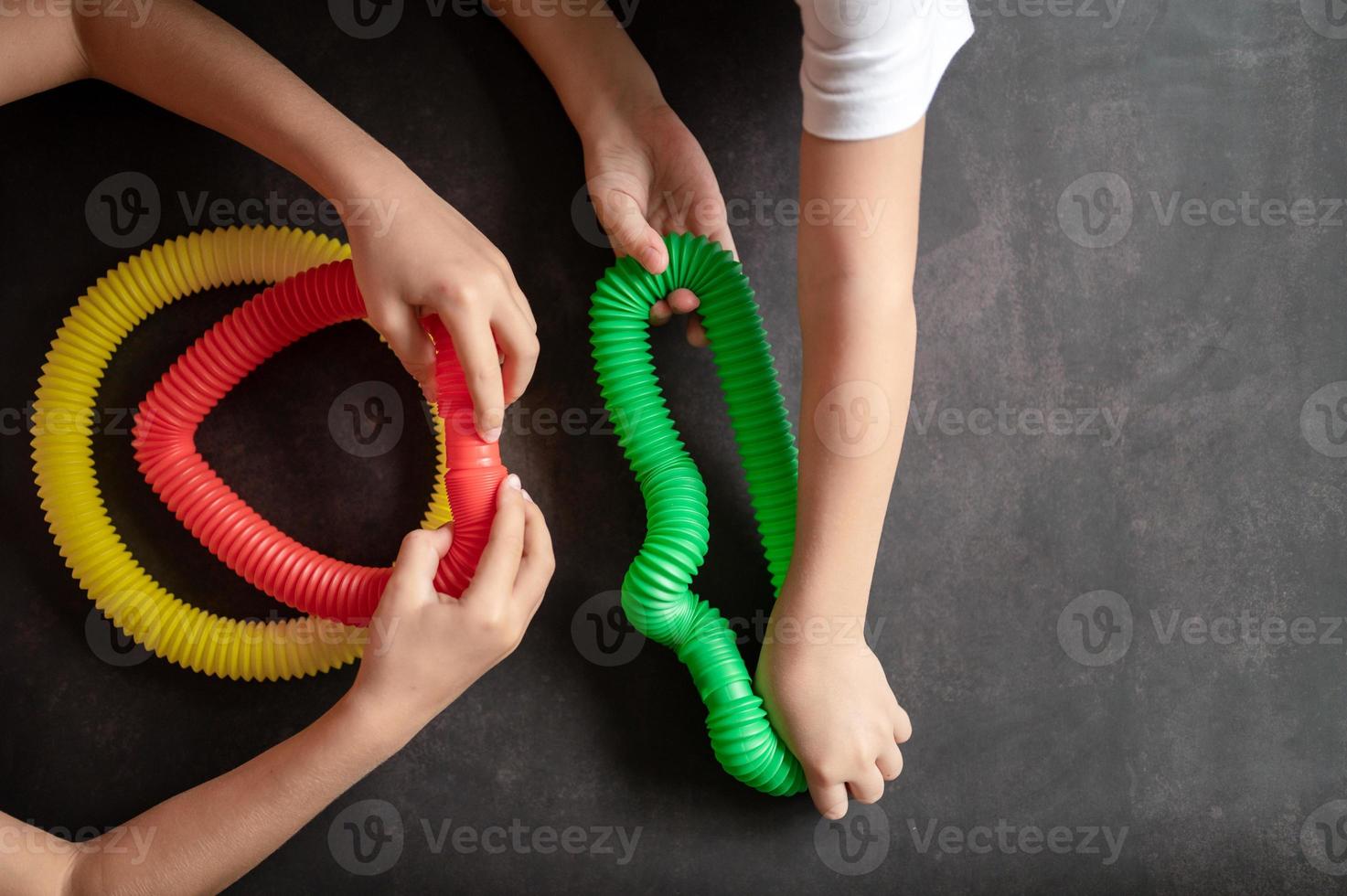 pop tubo poptube criança crianças brinquedo anti-stress mãos segurando brincando foto