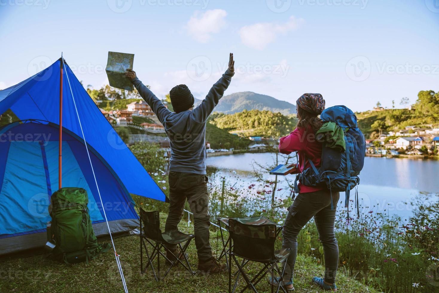 casal asiático acampa na montanha na aldeia superior perto do lago, conceito de viagens de acampamento, mapa de conceito de relaxamento de viagens. foto