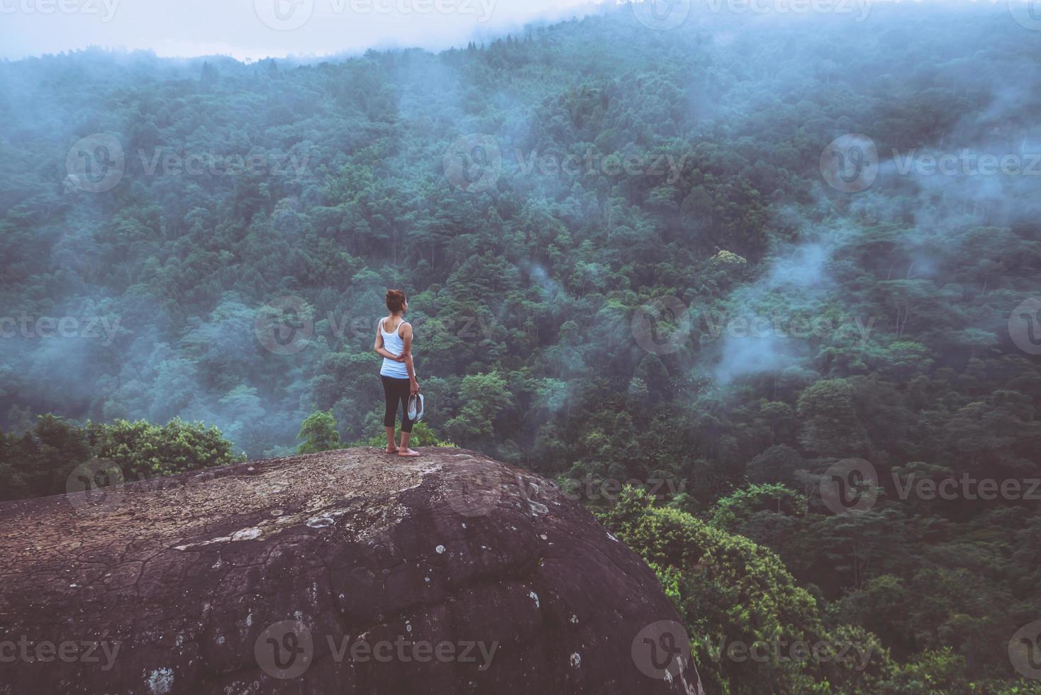 mulheres asiáticas viajam relaxam no feriado. em pé com as mãos em um penhasco rochoso. madeira da natureza selvagem na montanha. foto