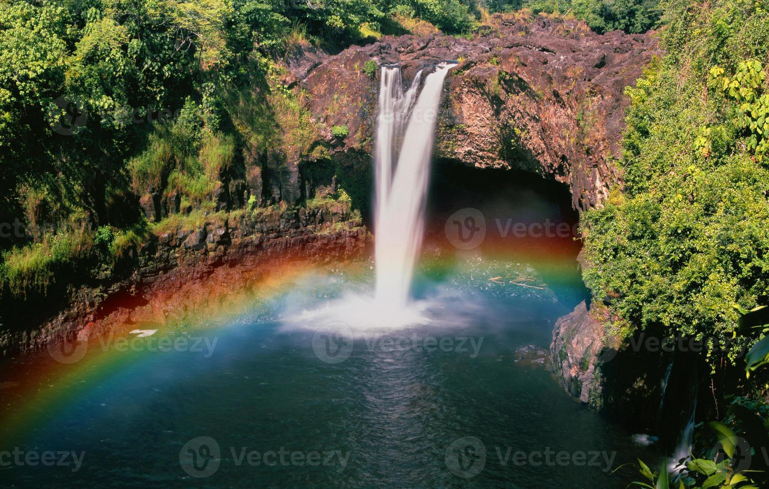 arco-íris colorido ambiente verão ensolarado floresta de abetos com grama e árvores na cachoeira foto