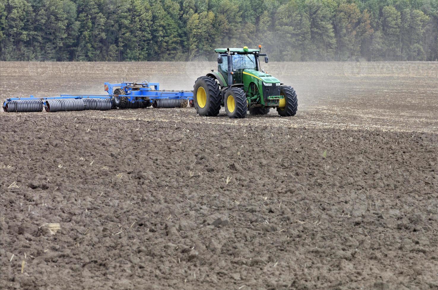 trator no campo cultiva o solo após a colheita. foto