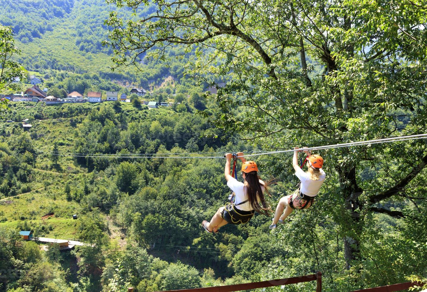 os turistas atravessam o longo caminho através da montanha e da floresta ao longo da tiara do rio de teleférico. foto