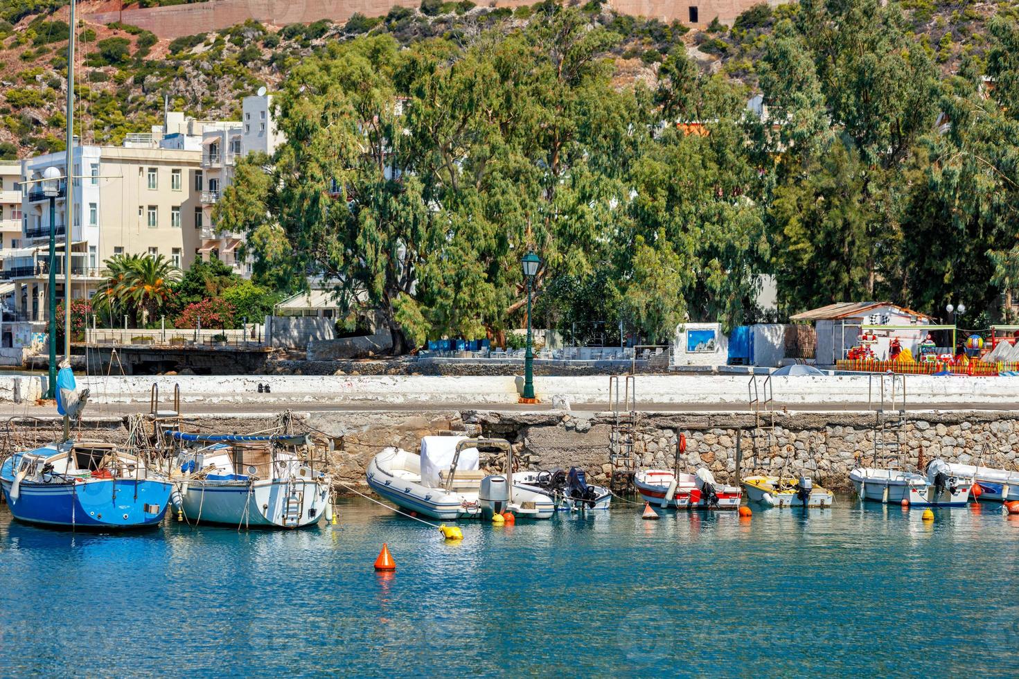 o pitoresco passeio da baía de loutraki, na grécia, onde antigas escunas de pesca, barcos e barcos atracam nas águas cristalinas do mar iônico. foto