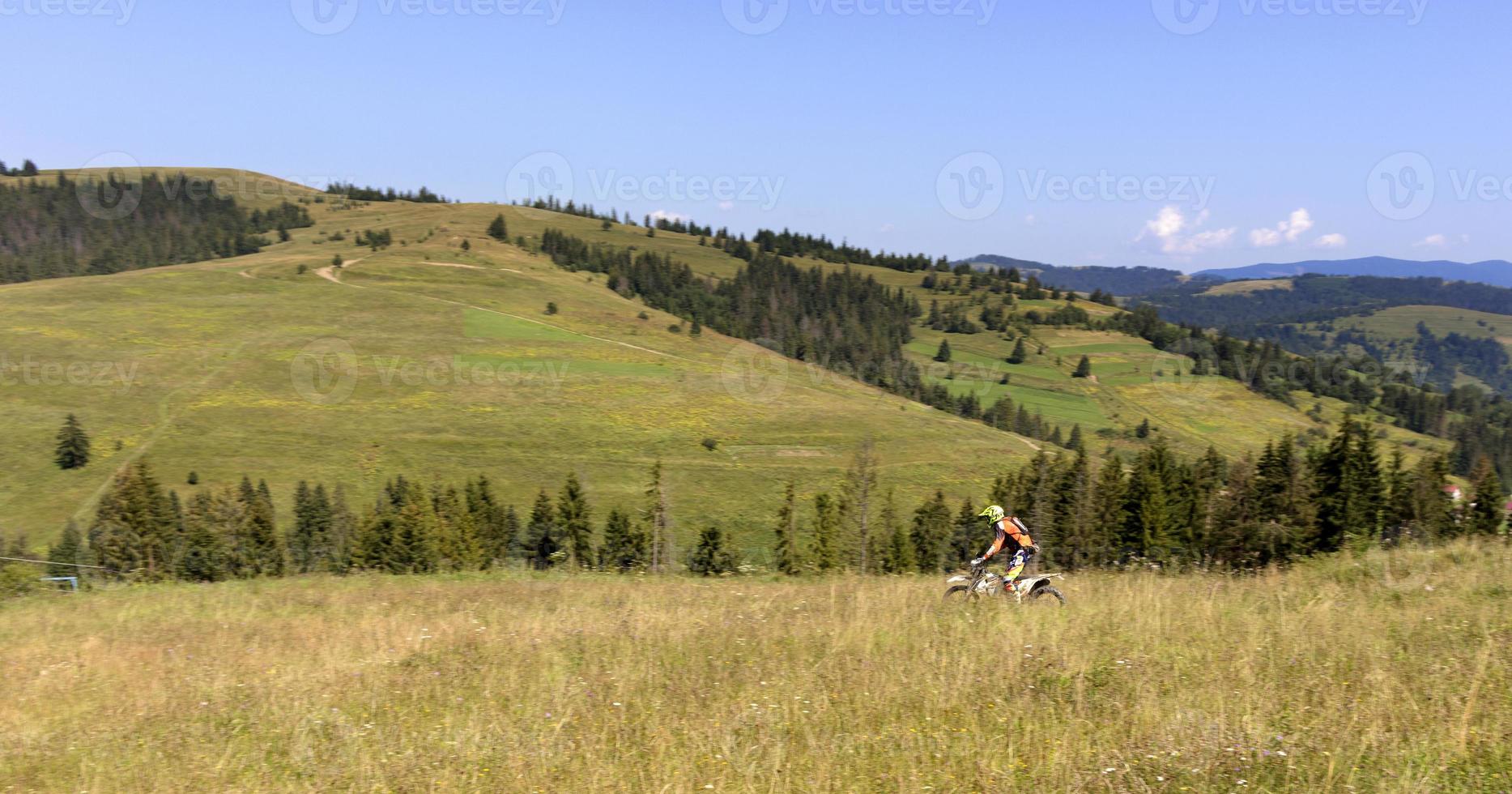 motociclista desce a encosta das montanhas dos Cárpatos foto