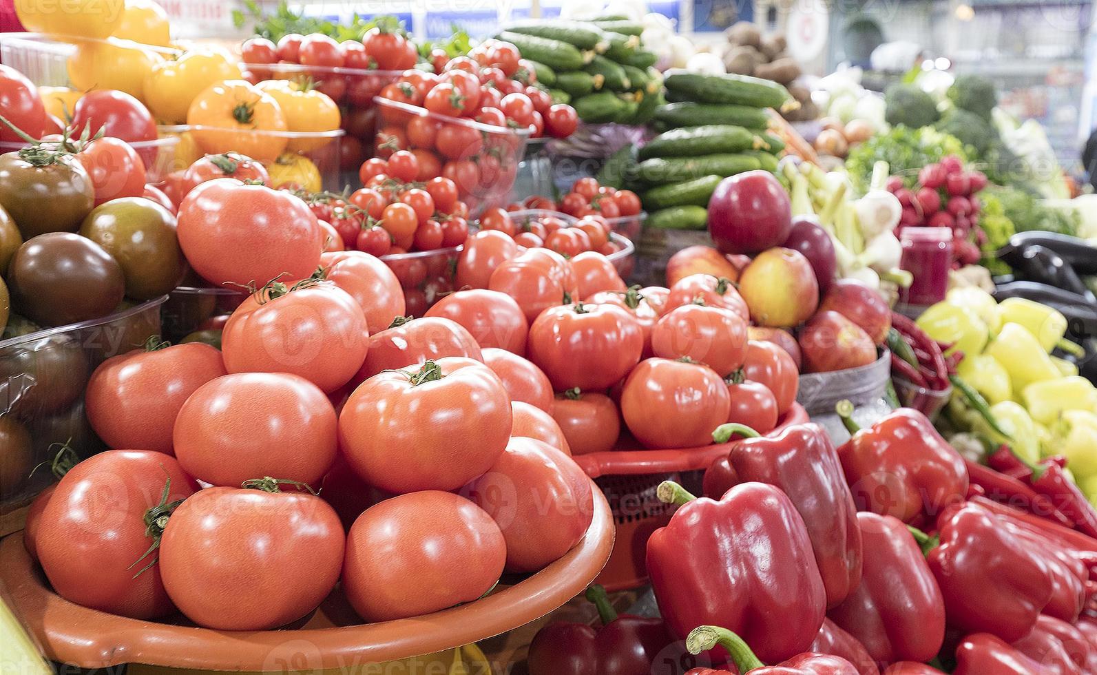 tomates, pepinos, pimentões e outros vegetais à venda no mercado foto