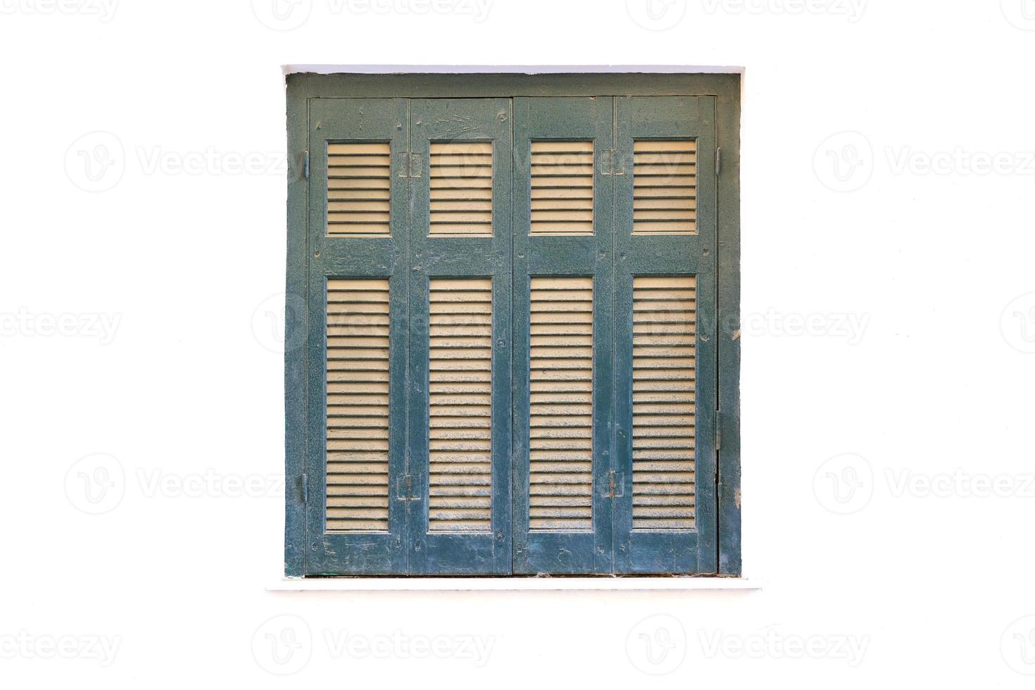 persianas de madeira na janela da antiga fachada branca da casa. foto