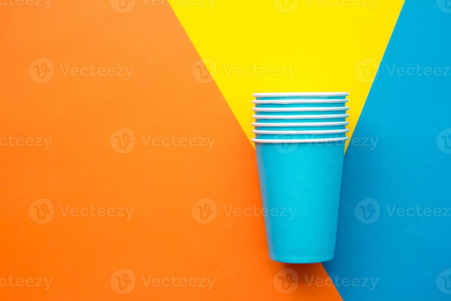 copos descartáveis de papel azul em um fundo multicolorido bonito foto