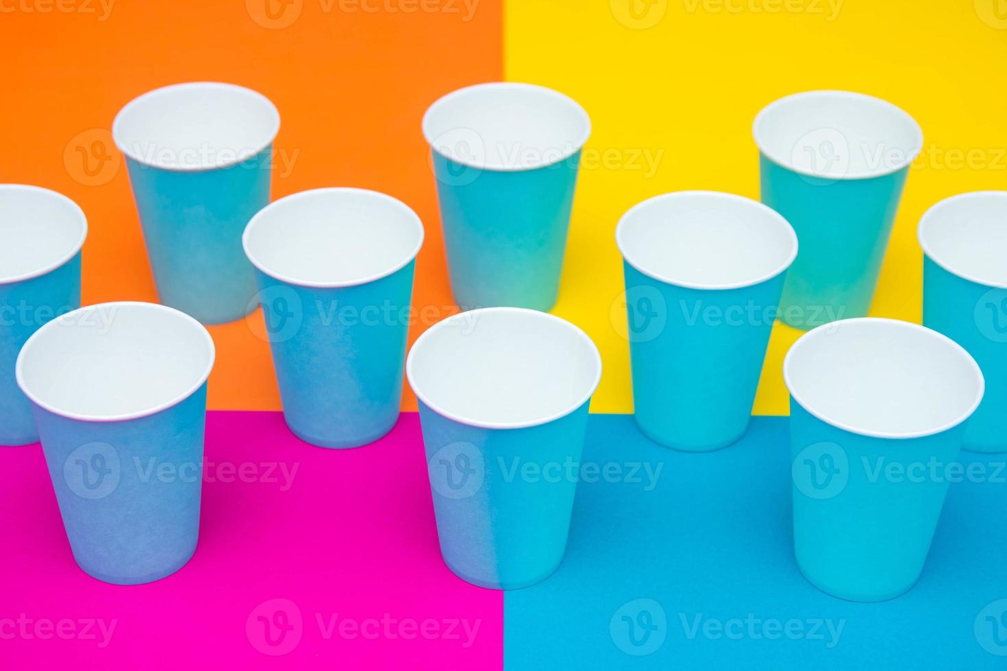 copos descartáveis de papel azul em um fundo multicolorido bonito foto