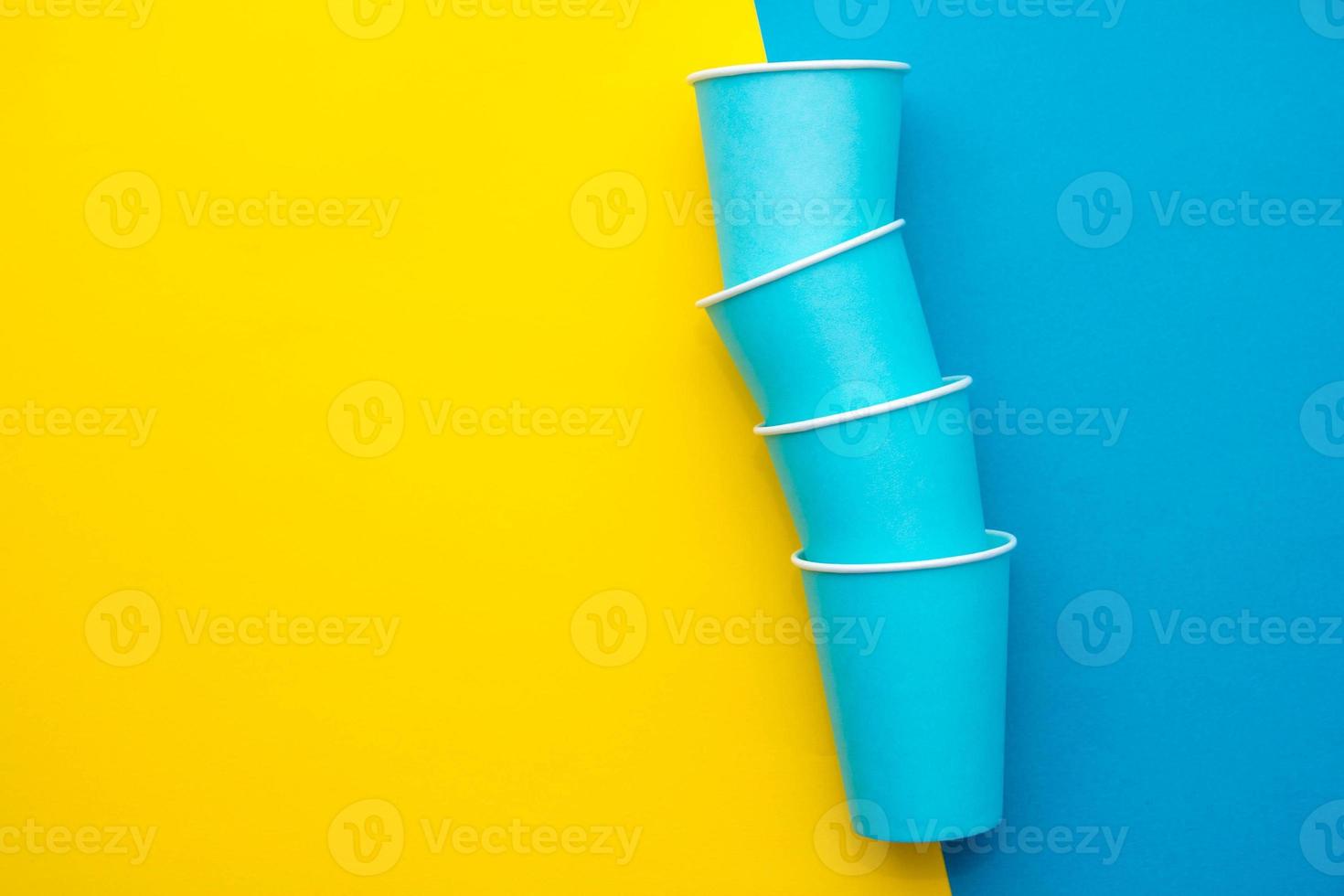 copos descartáveis de papel azul fundo amarelo e azul foto