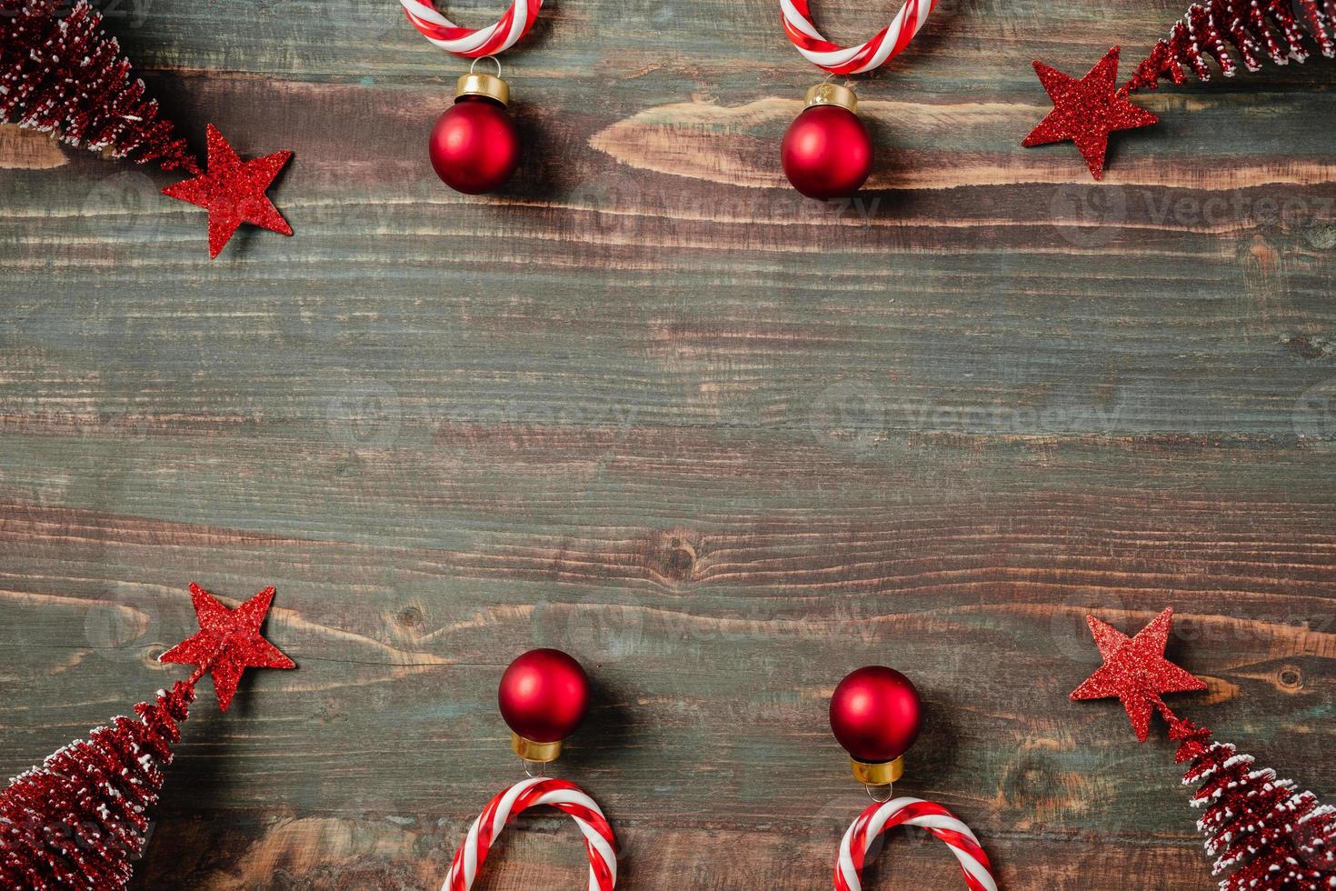 bola de natal, enfeite de decoração de árvore de pinho de cana-de-doce no fundo de madeira da mesa foto