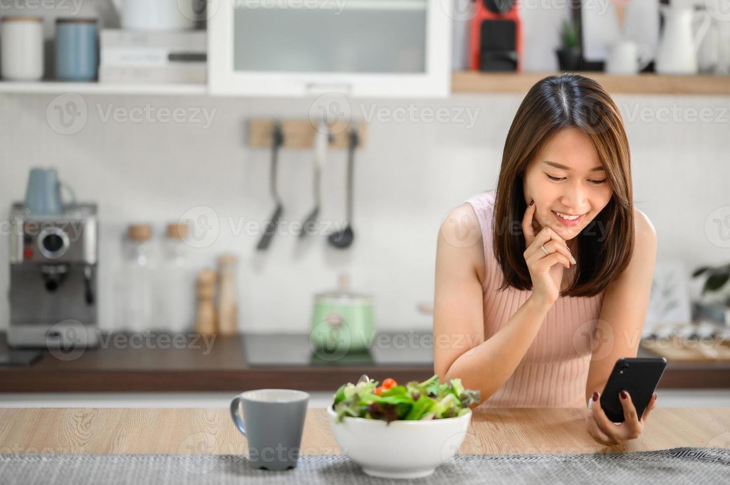 mulher asiática usando smartphone em casa foto