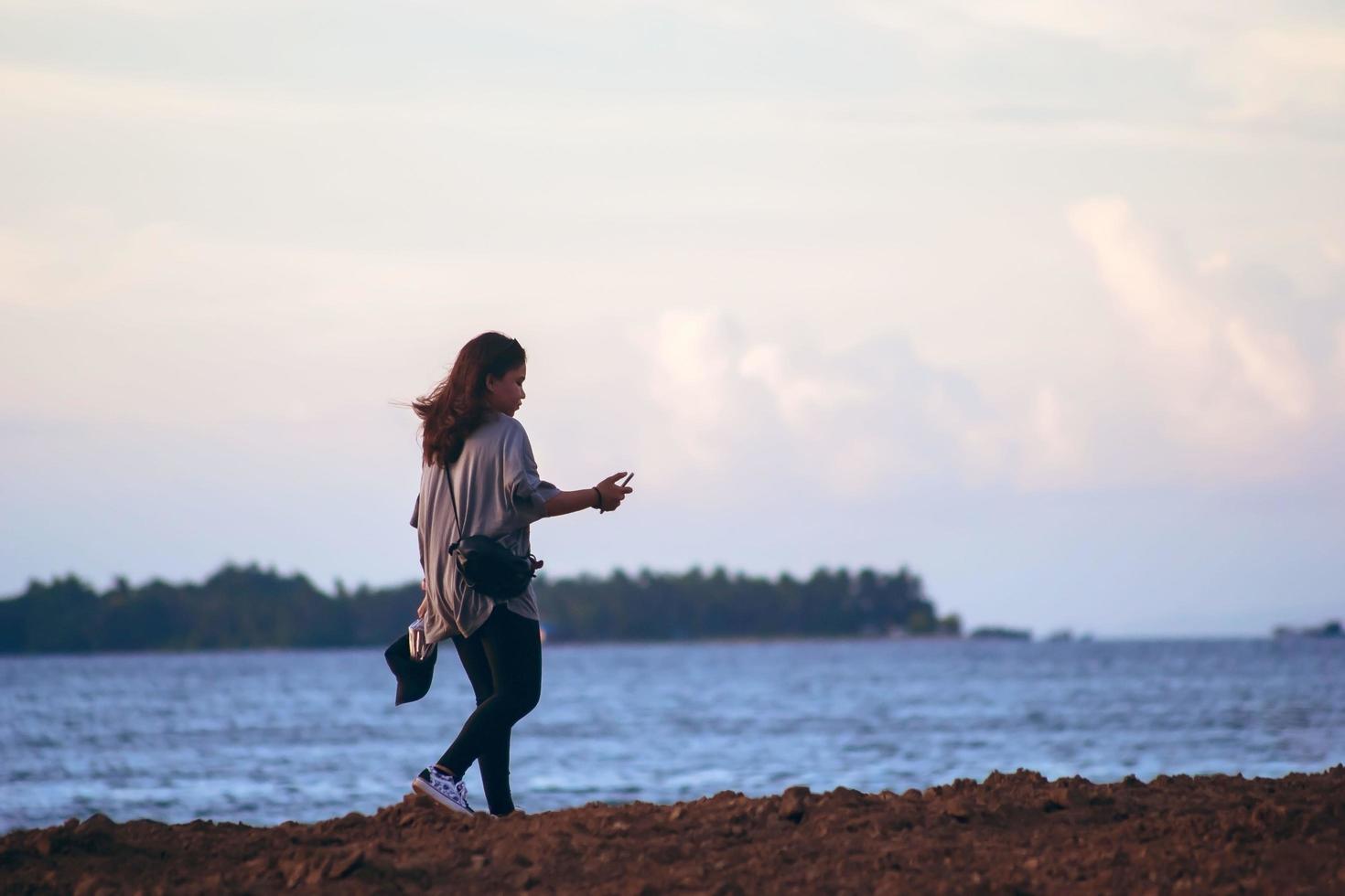 sorong, west papua, indonesia 2021 - menina sozinha na praia ao anoitecer. foto