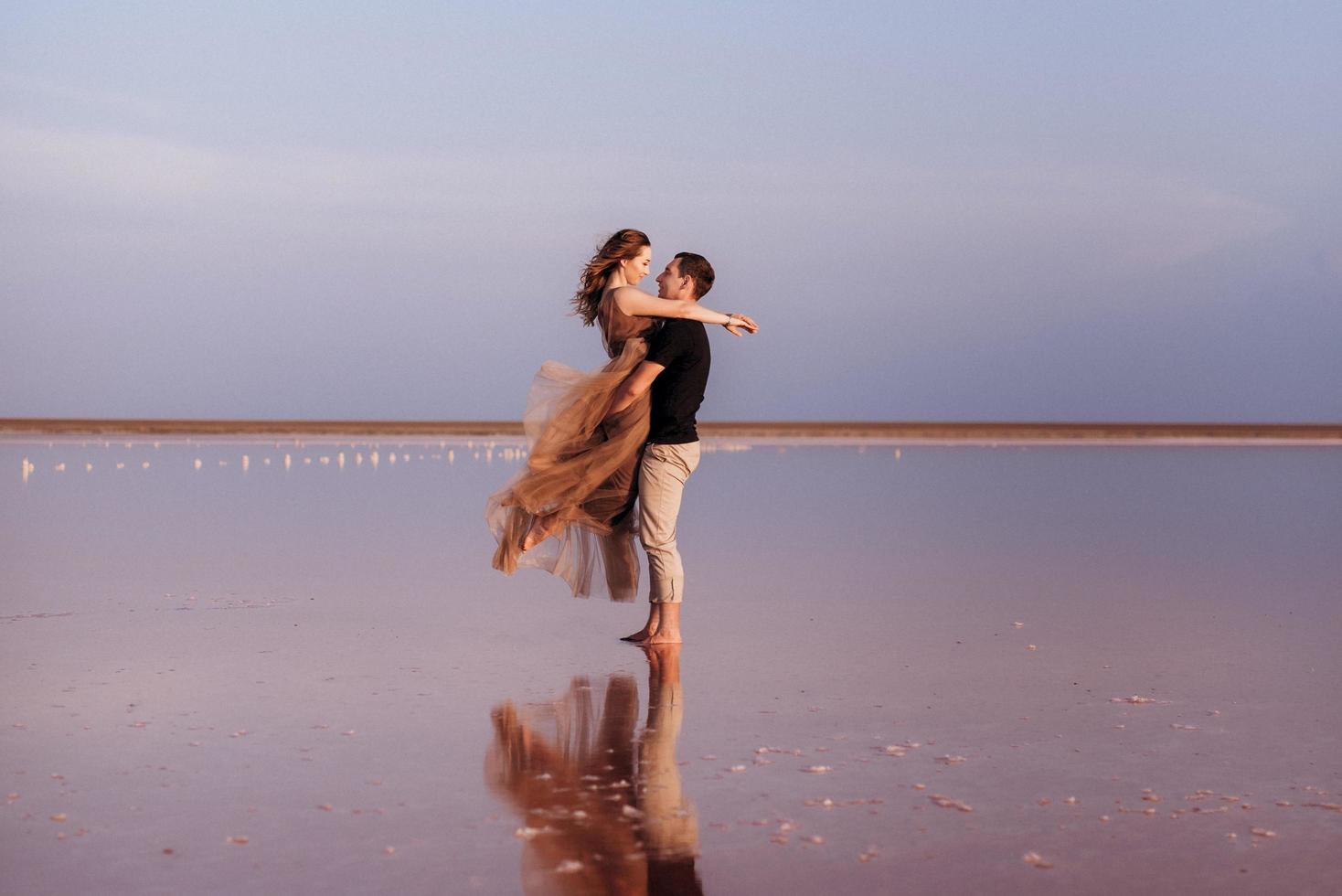 garota e um cara na margem de um lago salgado rosa foto