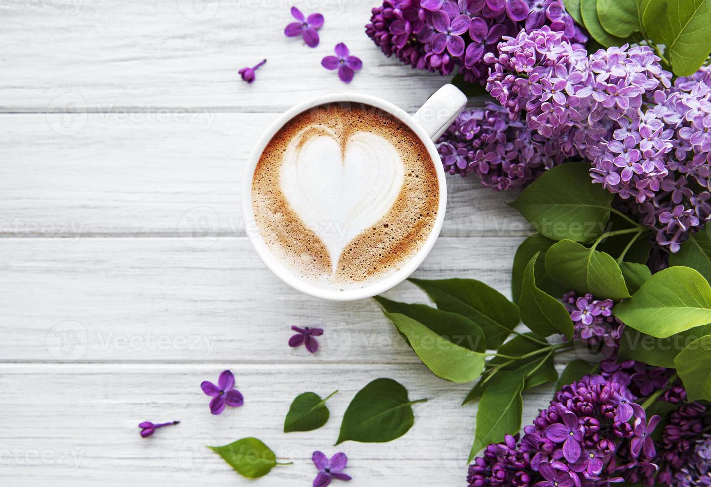 lilás e xícara de café em estilo simples, sobre fundo branco de madeira. foto