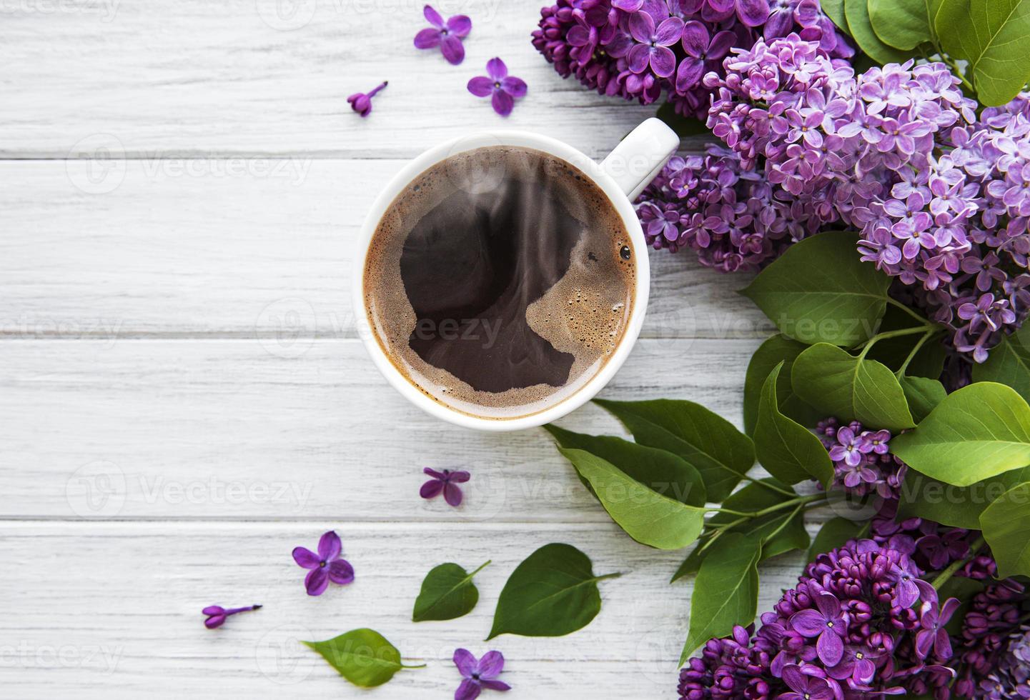 lilás e xícara de café em estilo simples, sobre fundo branco de madeira. foto