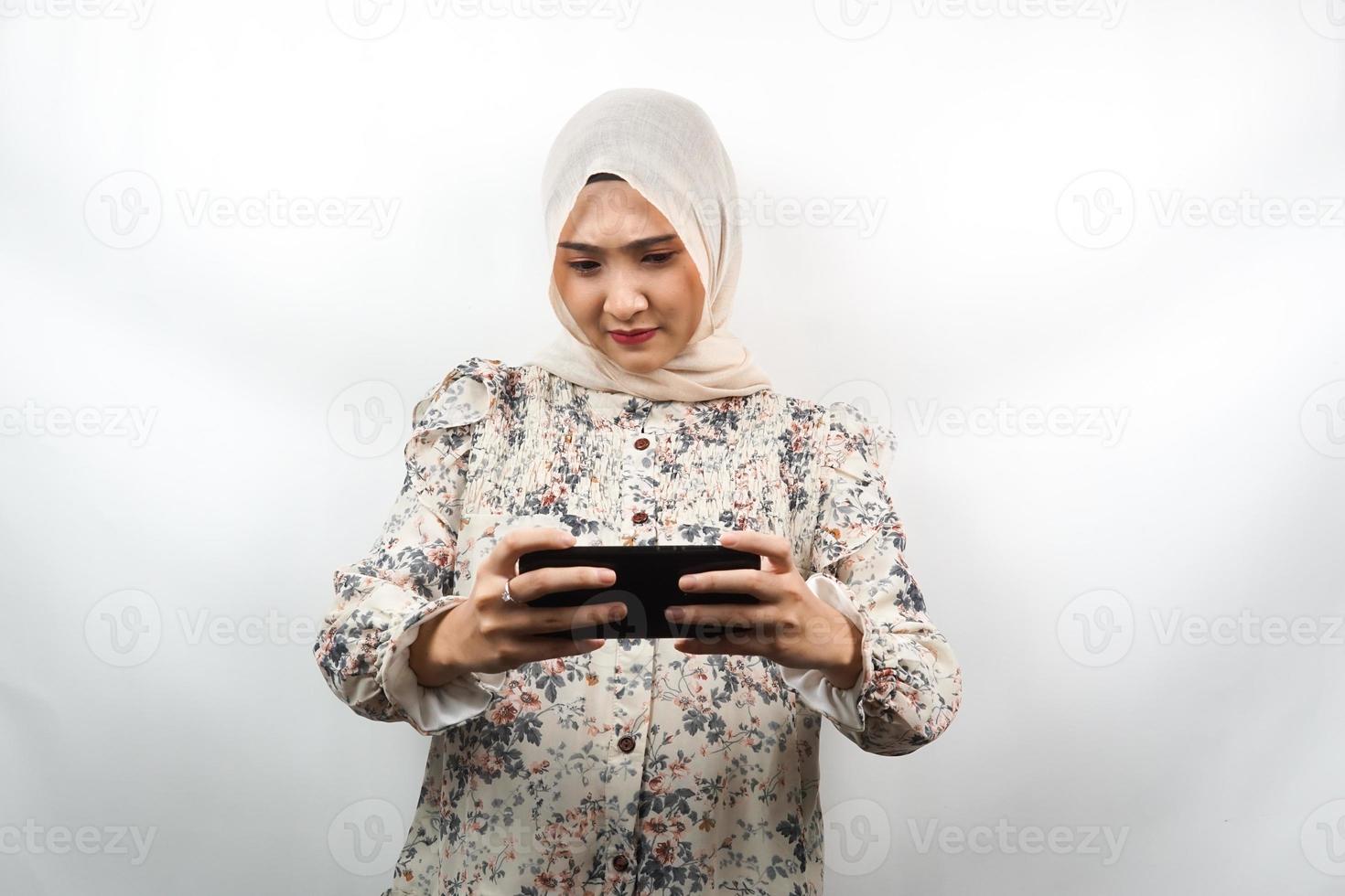 linda jovem muçulmana asiática com a mão segurando um smartphone, jogando, triste, derrota, infeliz, isolado no fundo branco, conceito de publicidade foto