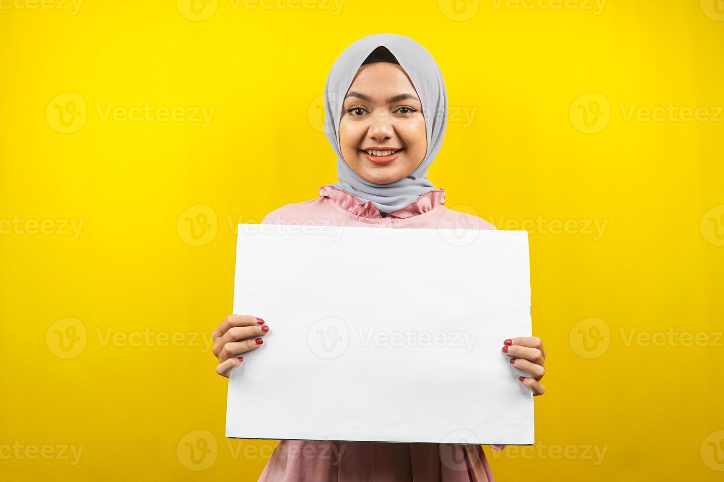 muito jovem mulher muçulmana alegre segurando uma faixa vazia em branco, cartaz, quadro branco, placa de sinalização em branco, quadro de propaganda branco, apresentando algo no espaço da cópia, promoção foto