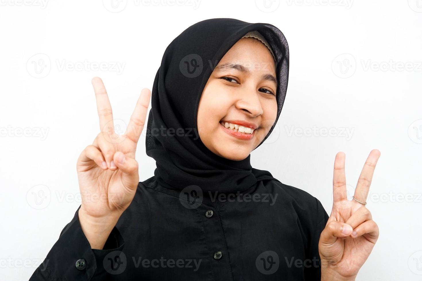 close up de uma bela jovem muçulmana, sorrindo com dois dedos, vitória, isolada foto