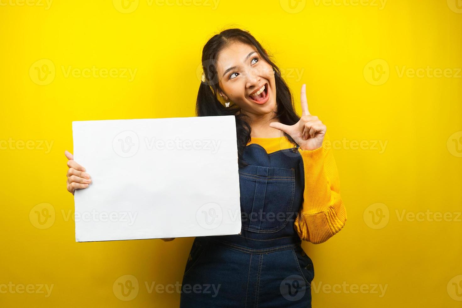 jovem bonita e fofa alegre segurando uma faixa vazia em branco, cartaz, quadro branco, placa de sinalização em branco, quadro de propaganda branco, apresentando algo no espaço da cópia, promoção foto