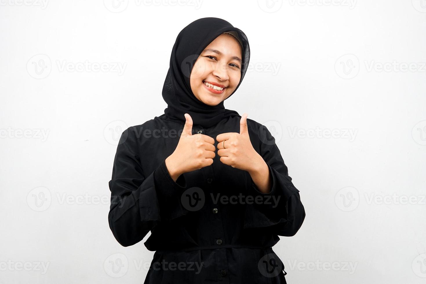 bela jovem asiática muçulmana com mãos polegares para cima, sinal de ok, bom trabalho, sucesso, vitória, sorrindo confiante, entusiasmado e alegre, olhando para a câmera isolada no fundo branco foto