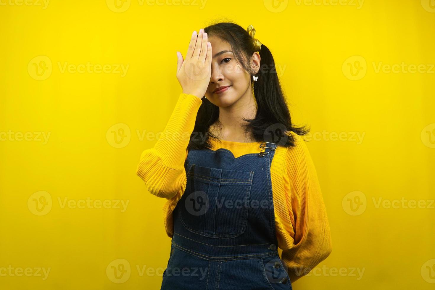 Mulher jovem bonita e fofa com a mão fechada em um olho isolado foto