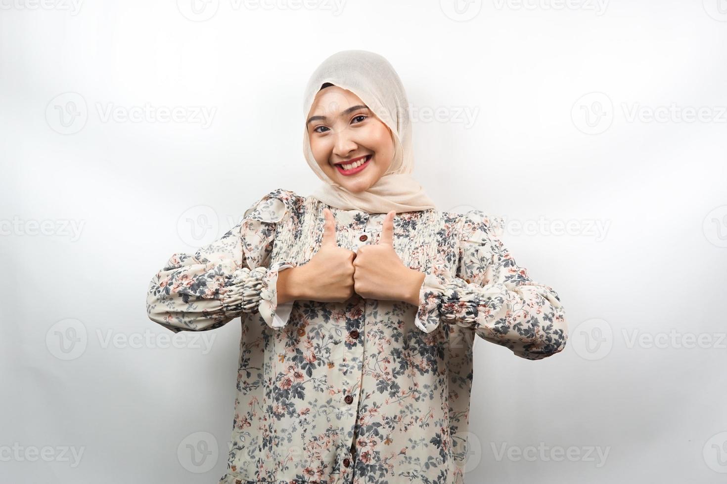 bela jovem asiática muçulmana com mãos polegares para cima, sinal de ok, bom trabalho, sucesso, vitória, sorrindo confiante, entusiasmado e alegre, olhando para a câmera isolada no fundo branco foto