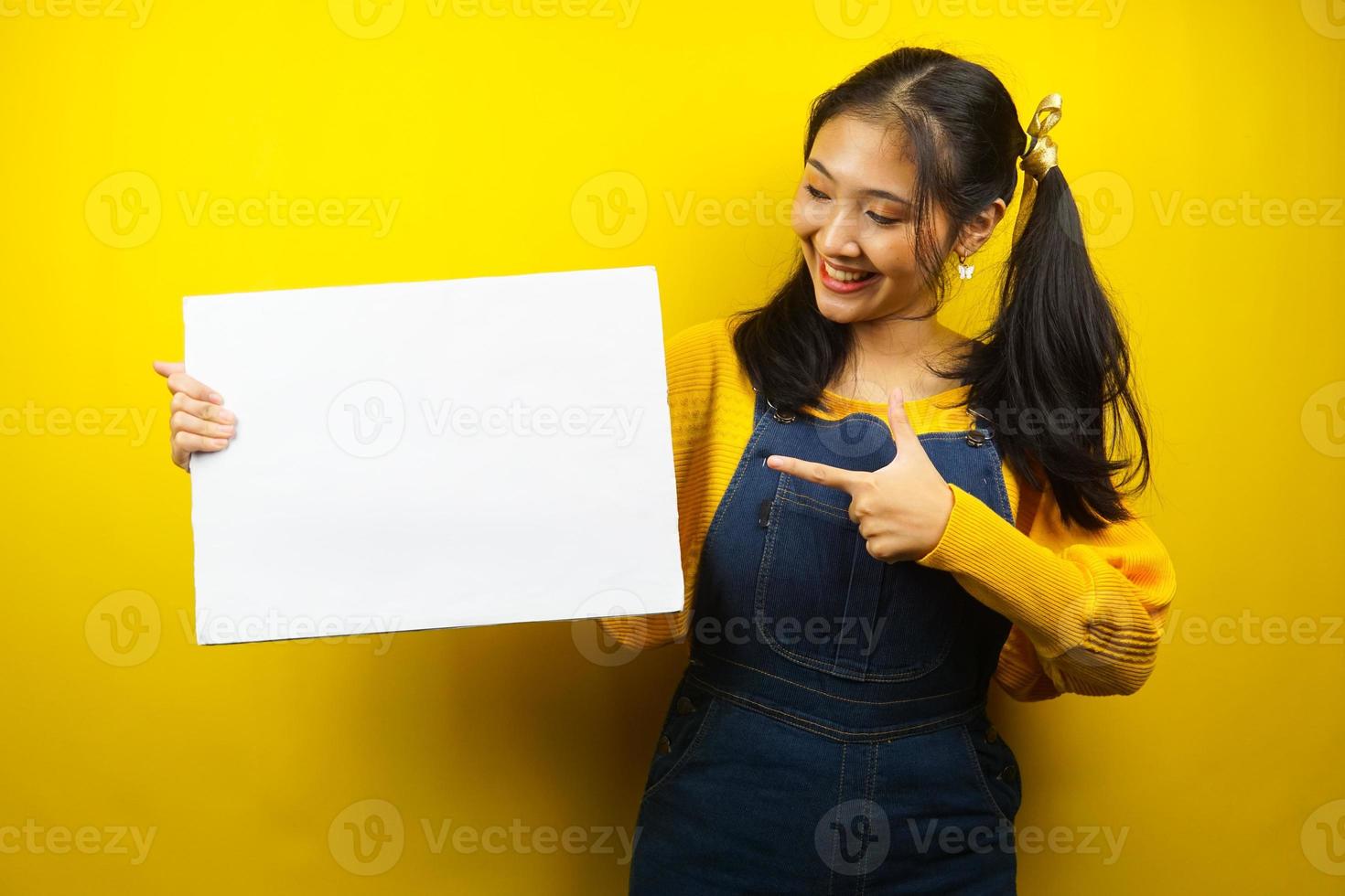 jovem bonita e fofa alegre segurando uma faixa vazia em branco, cartaz, quadro branco, placa de sinalização em branco, quadro de propaganda branco, apresentando algo no espaço da cópia, promoção foto